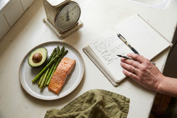 Meal planning with salmon, vegetables and a notebook